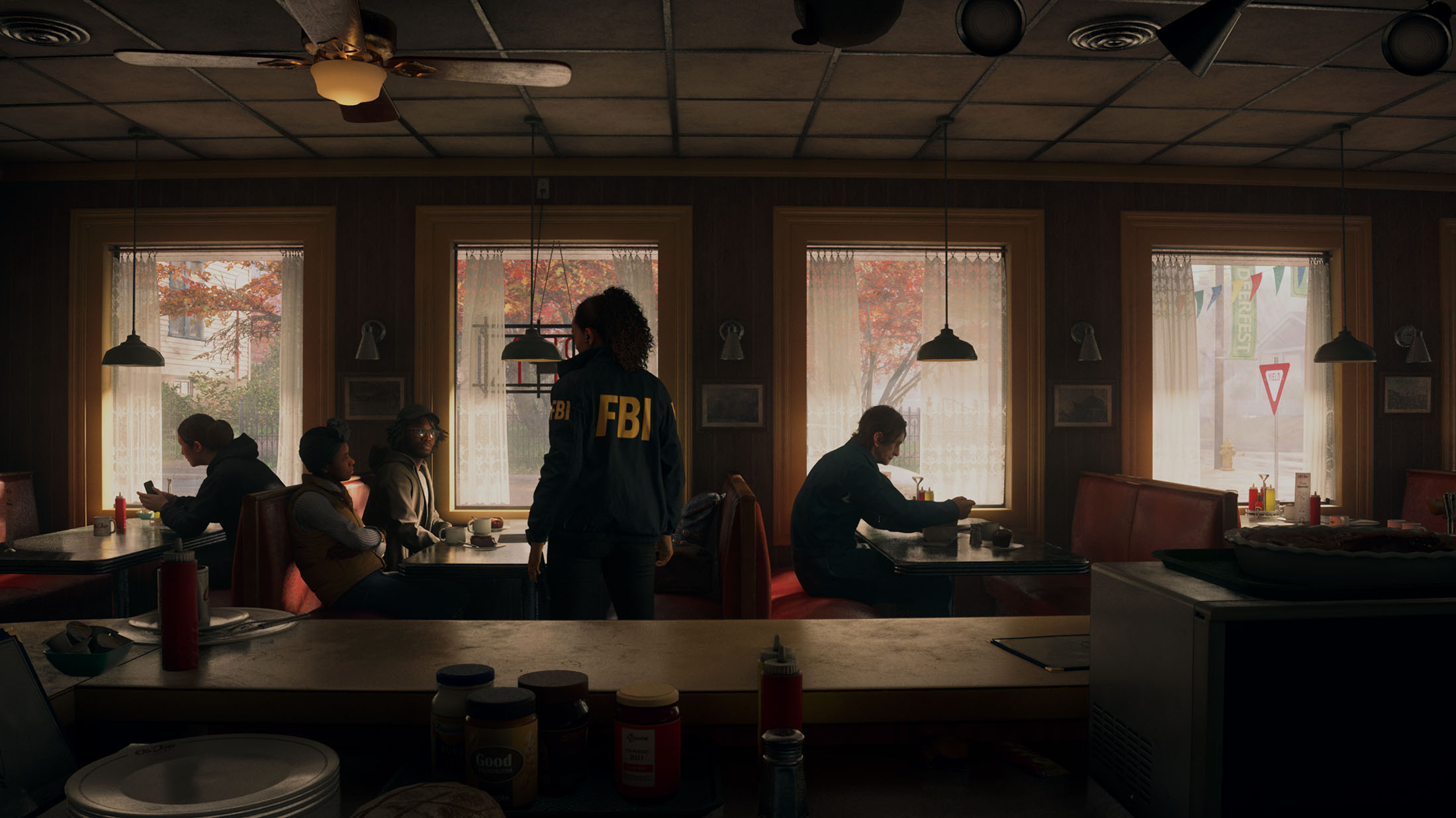 Screenshot aus Alan Wake 2, der das Innere eines Diners zeigt mit einer FBI-Agentin.